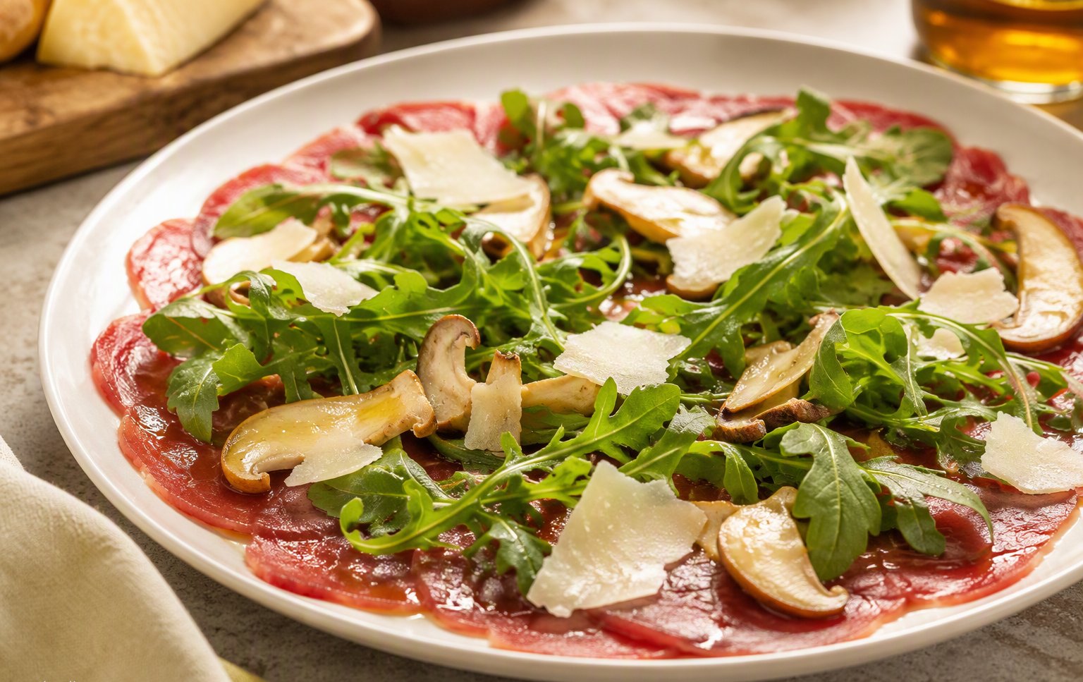 Il carpaccio con rucola, funghi e scaglie di parmigiano